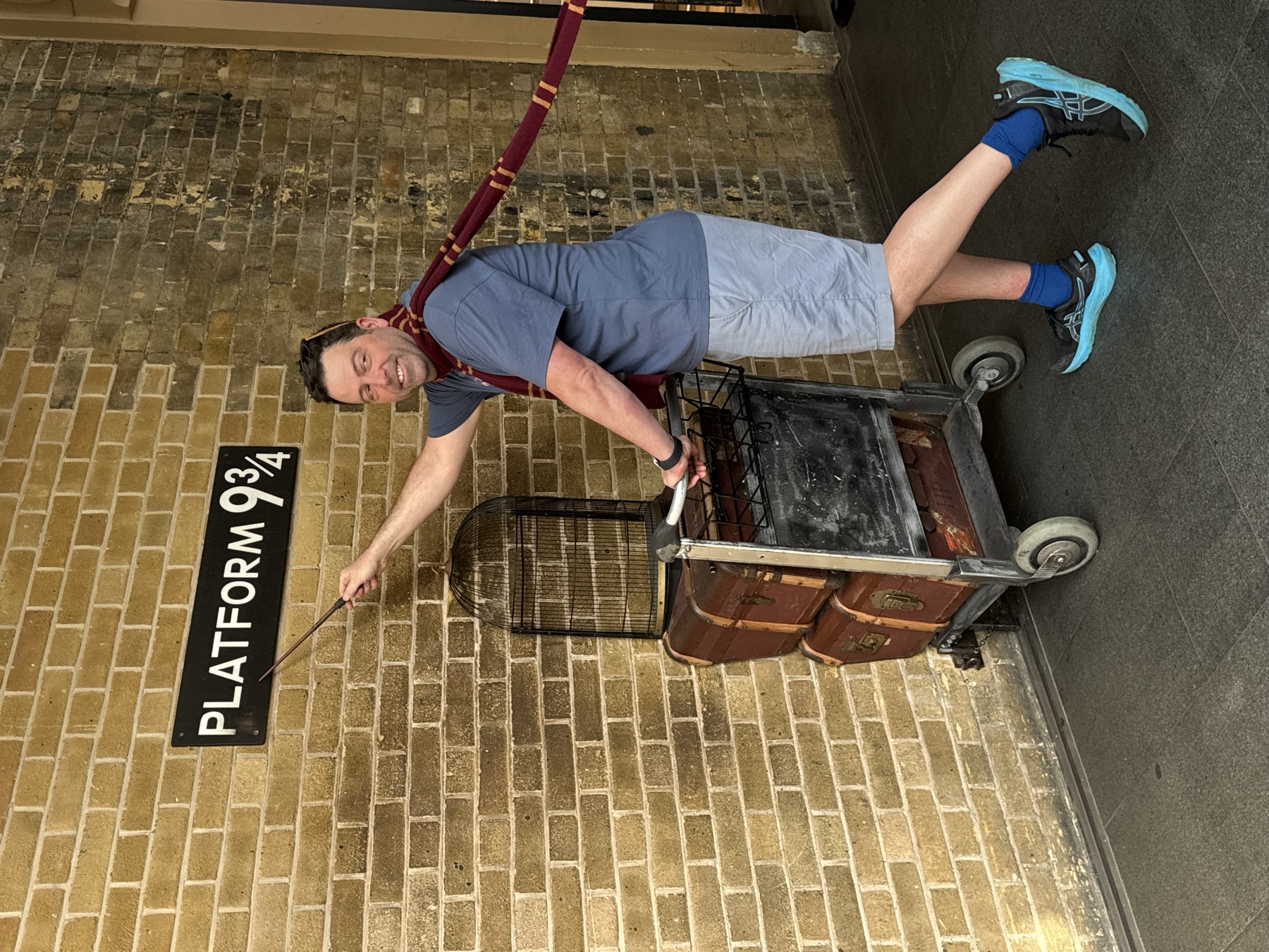 Derek posing with a luggage trolley at Platform Nine and Three-Quarters