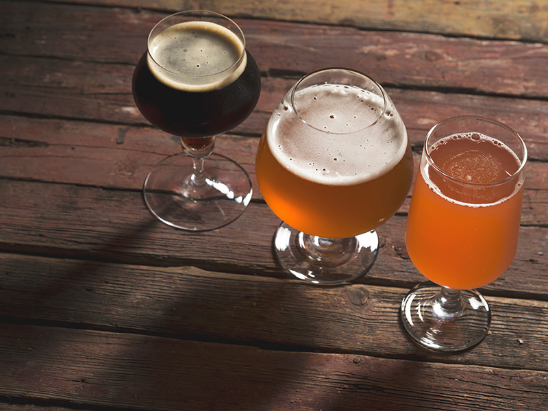 Three glasses of craft beer on a wooden table